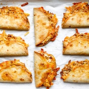 Crispy oven-baked chicken tacos on a sheet pan.