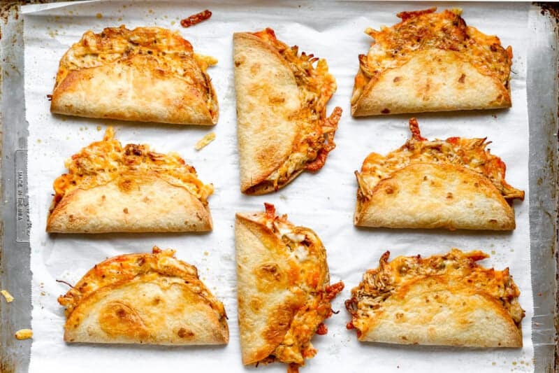 Crispy oven-baked chicken tacos on a sheet pan.