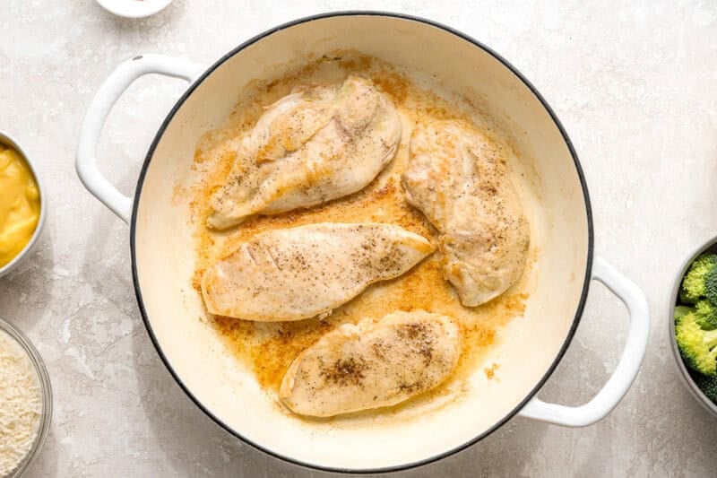 Seared chicken breasts in a pan.