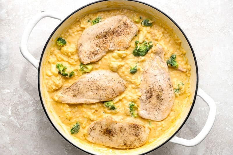 Chicken breasts placed over cheesy rice and broccoli mixture.