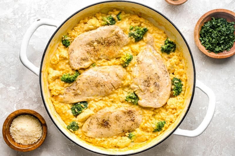 Cooked chicken breasts over cheesy Velveeta rice and broccoli.