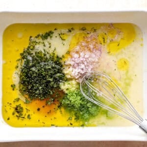 Combining mint, lime, rum, and other marinade ingredients in a dish.