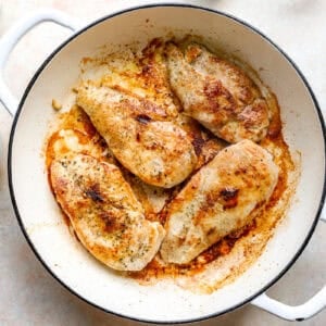 Seared chicken breasts in a pan.