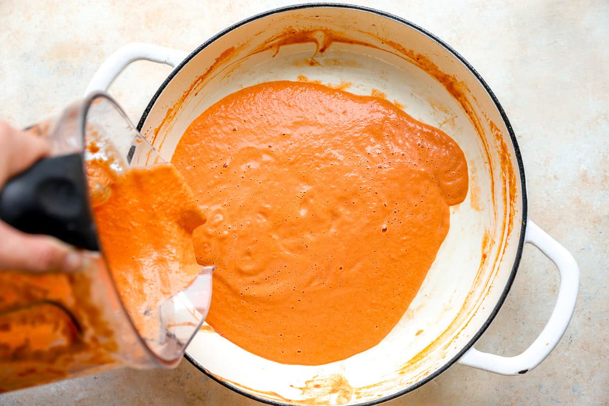 Pouring the creamy vodka sauce back into the pot.