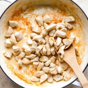 Cooking cubes of chicken in a skillet.