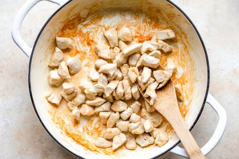 Cooking cubes of chicken in a skillet.