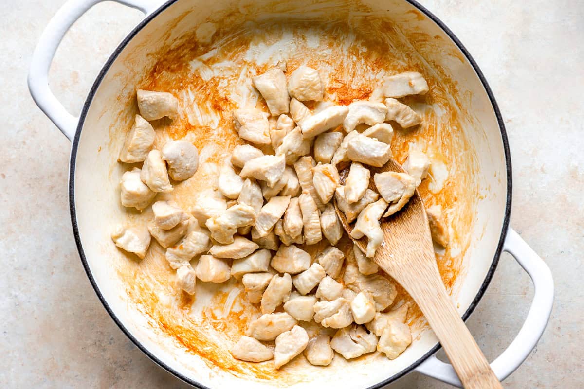Cooking cubes of chicken in a skillet.