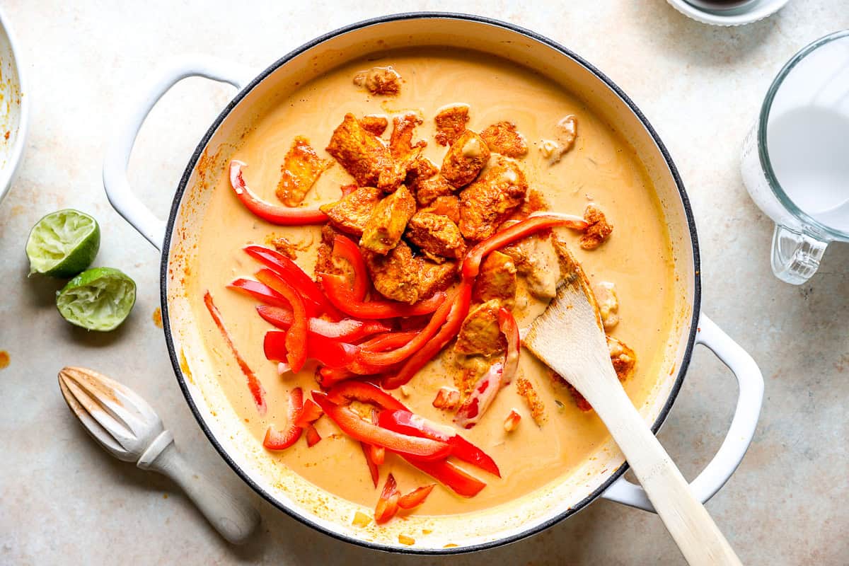 Chicken and pumpkin curry cooking in a skillet.