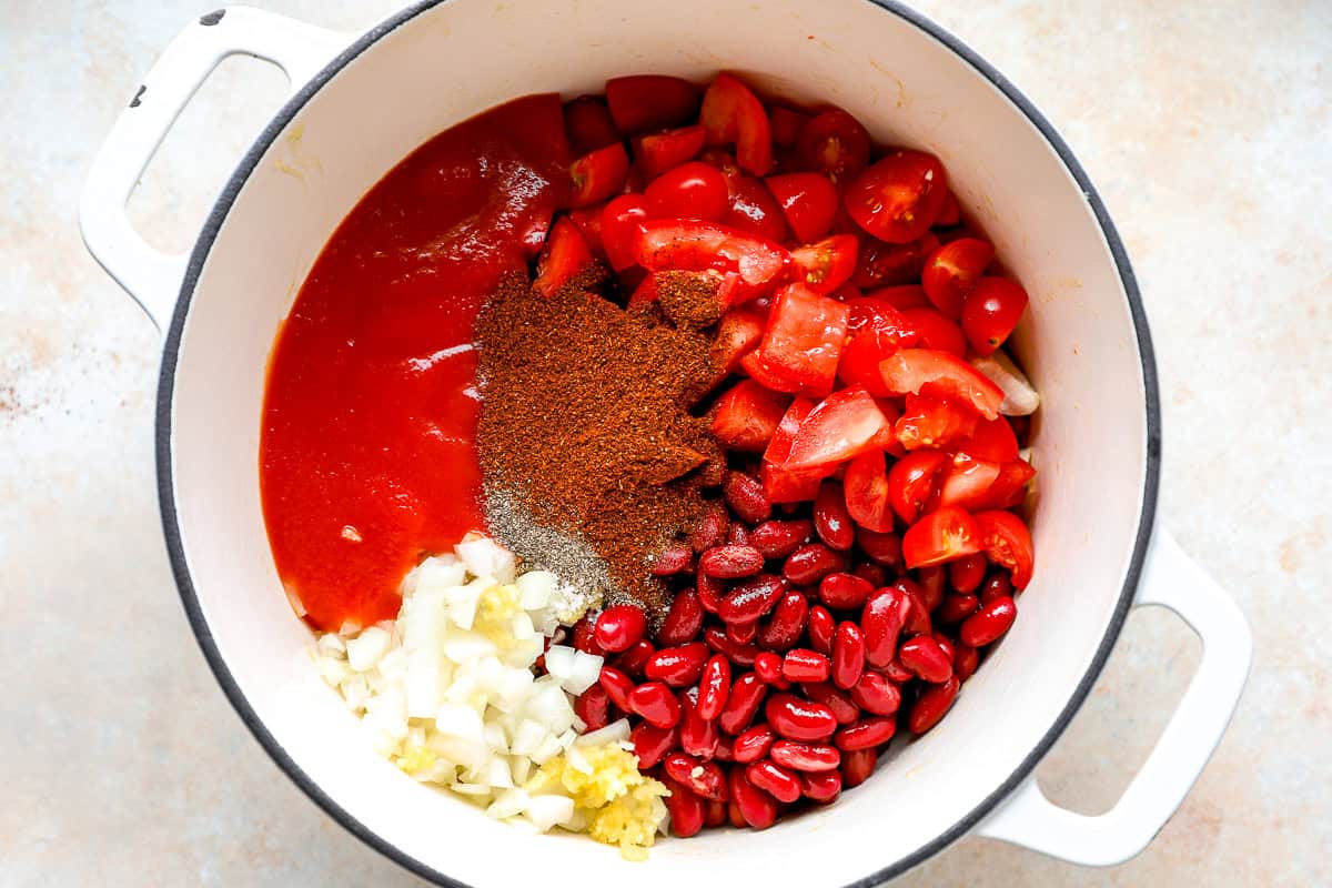 Red chili ingredients added to a Dutch oven.