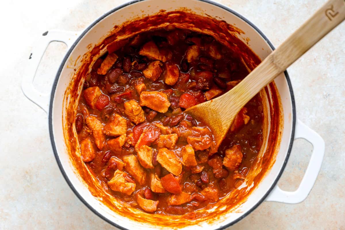 Cooking red chicken chili in a pot.