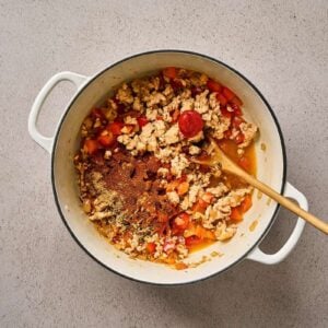 Cooking seasoned ground chicken and veggies in a pot.