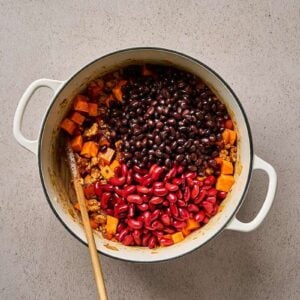 Beans added to a pot of sweet potatoes and ground chicken.