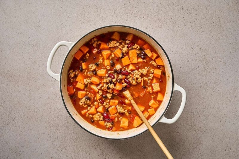 Sweet potato chicken chili ingredients combined in a pot.