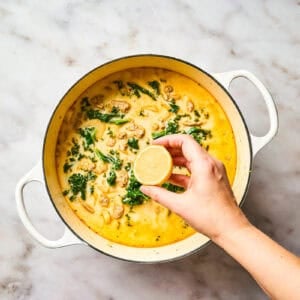 Finishing a pot of Zuppa Toscana soup with lemon juice.