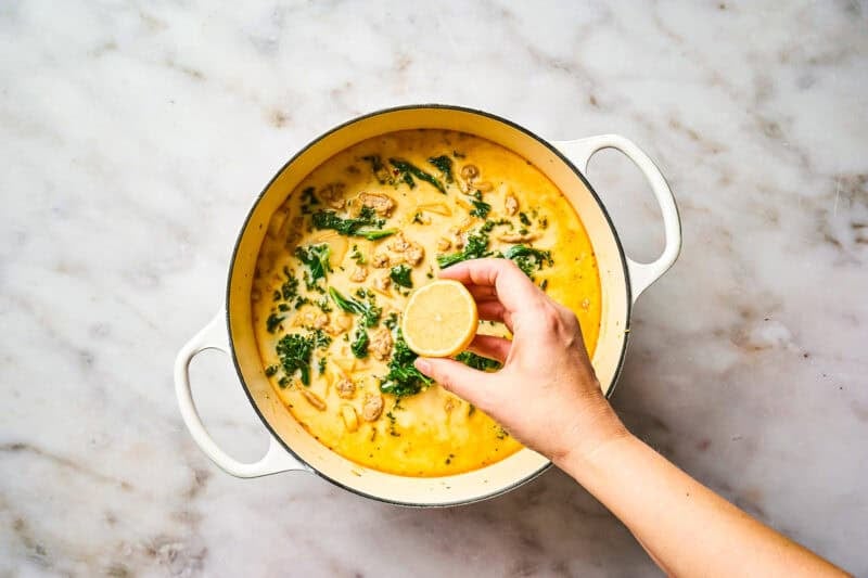 Finishing a pot of Zuppa Toscana soup with lemon juice.