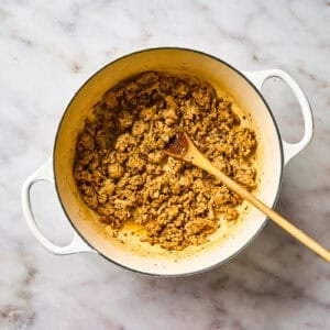 Cooking ground chicken in a pot.