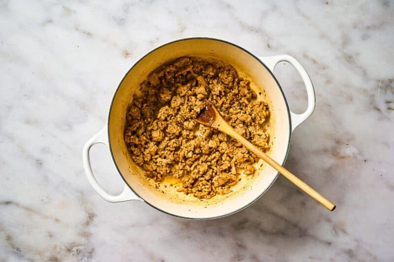 Cooking ground chicken in a pot.
