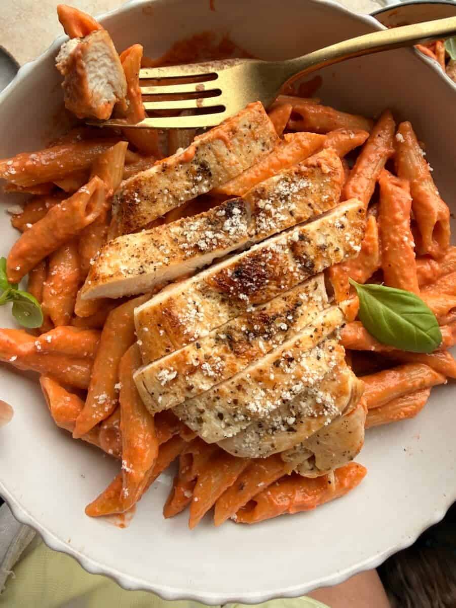 Eating a bowl of vodka pasta with chicken.