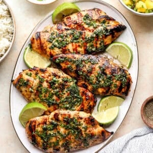 A plate of mojito grilled chicken topped with mint sauce.
