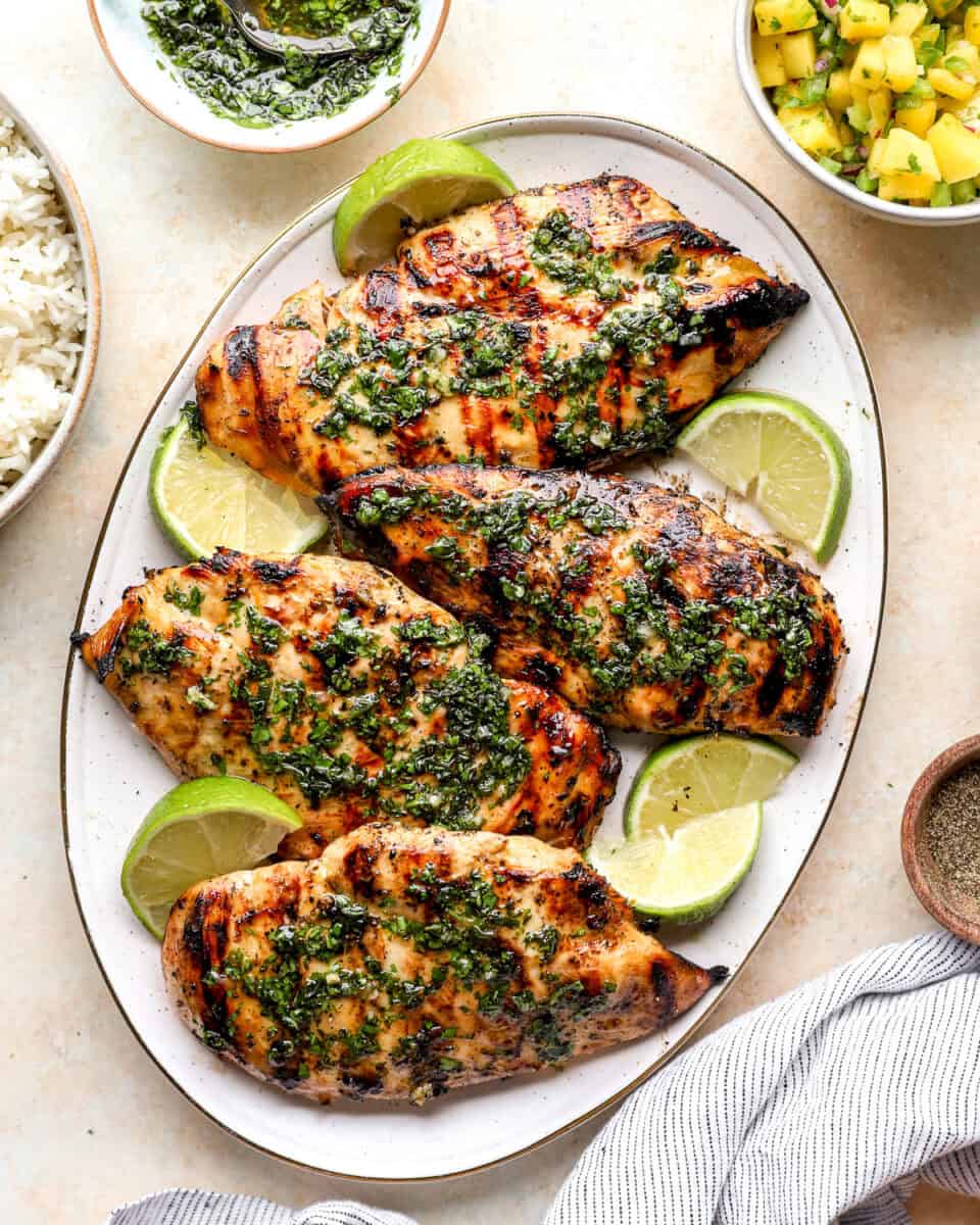A plate of mojito grilled chicken topped with mint sauce.