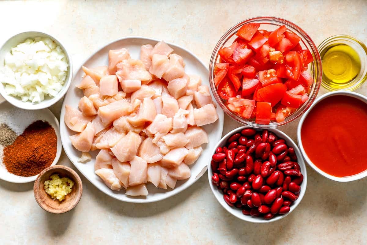 Ingredients for red chicken chili: chicken breast, kidney beans, tomatoes, tomato paste, and spices.