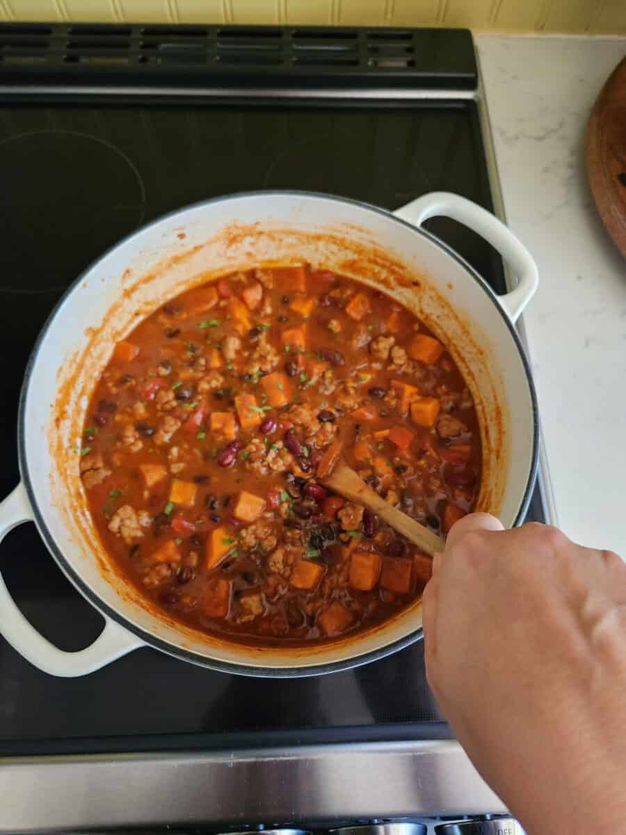Cooking sweet potato chili in a pot on the stove.