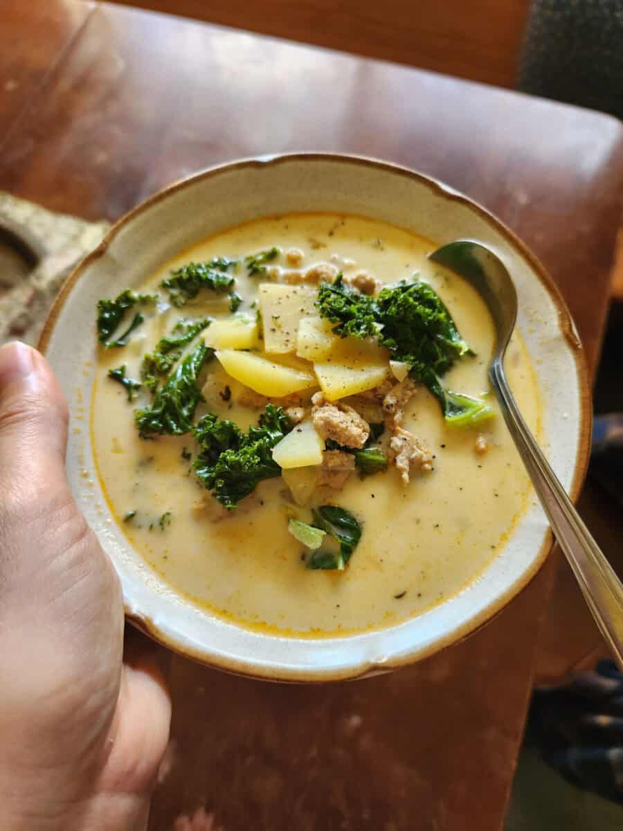 A bowl of Zuppa Toscana filled with potatoes, kale, and ground chicken.