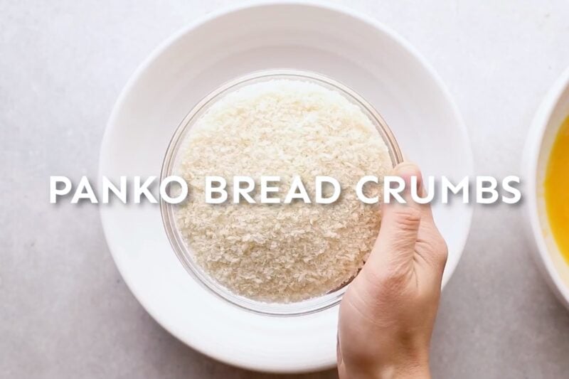 Adding panko breadcrumbs to a bowl.