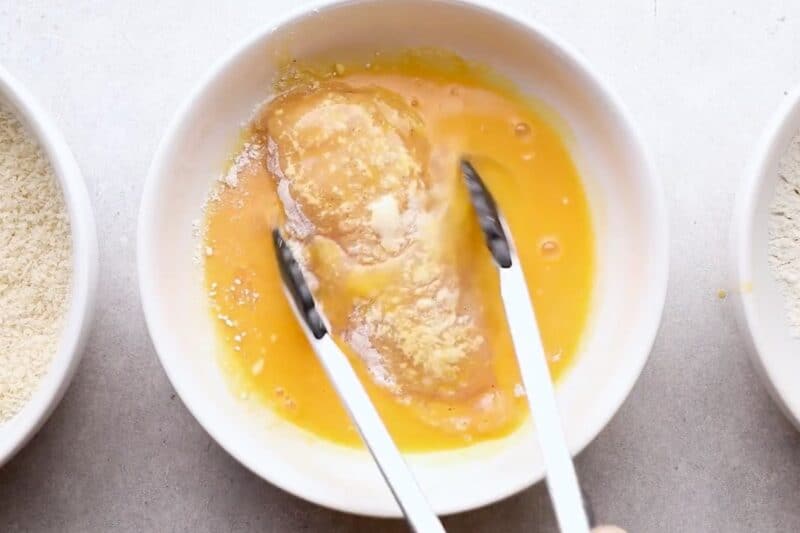 Dredging cutlet in egg.