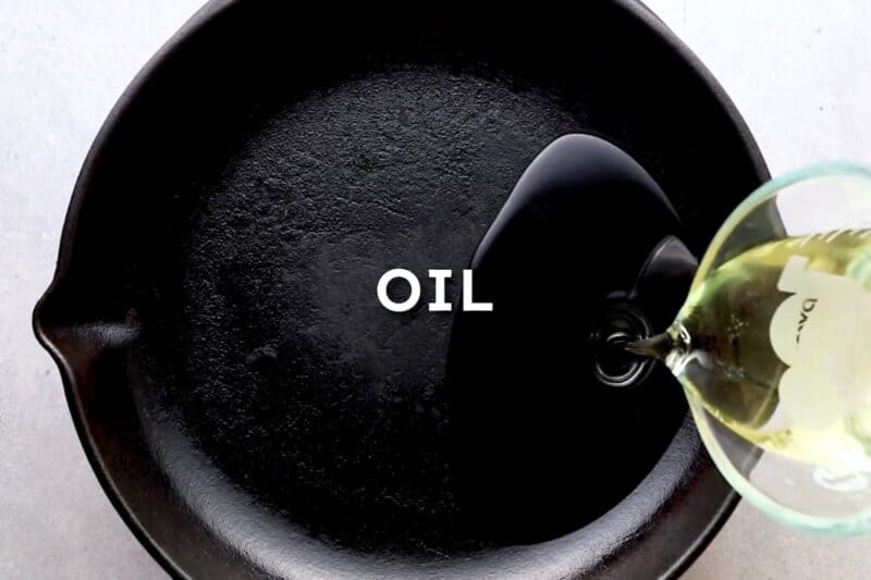 Adding oil to a skillet.